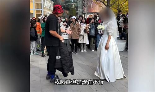 女生穿婚纱当街求婚却遭男友婉拒 女子满眼失望
